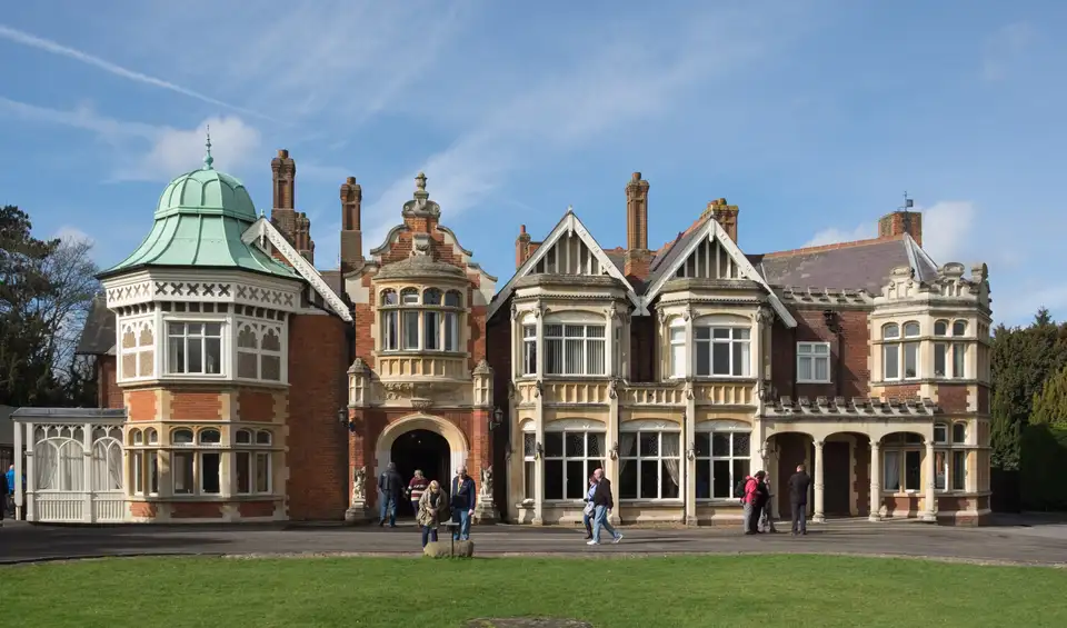 The Victorian mansion at Bletchley Park, a country house of red and buff brick with ornate gables and a copper dome