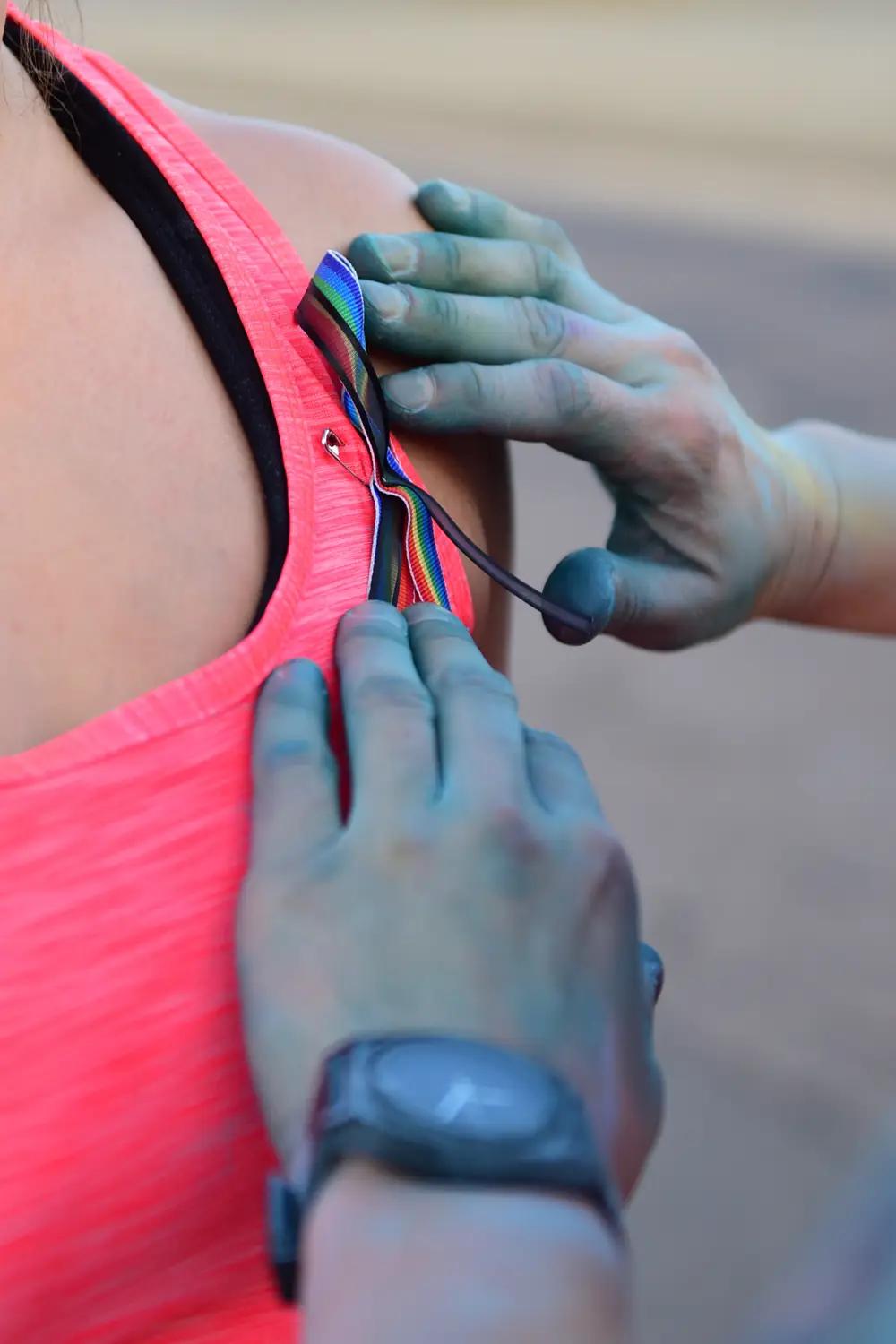 An airman pins a rainbow remembrance ribbon at a Pride 5K honoring the Pulse victims